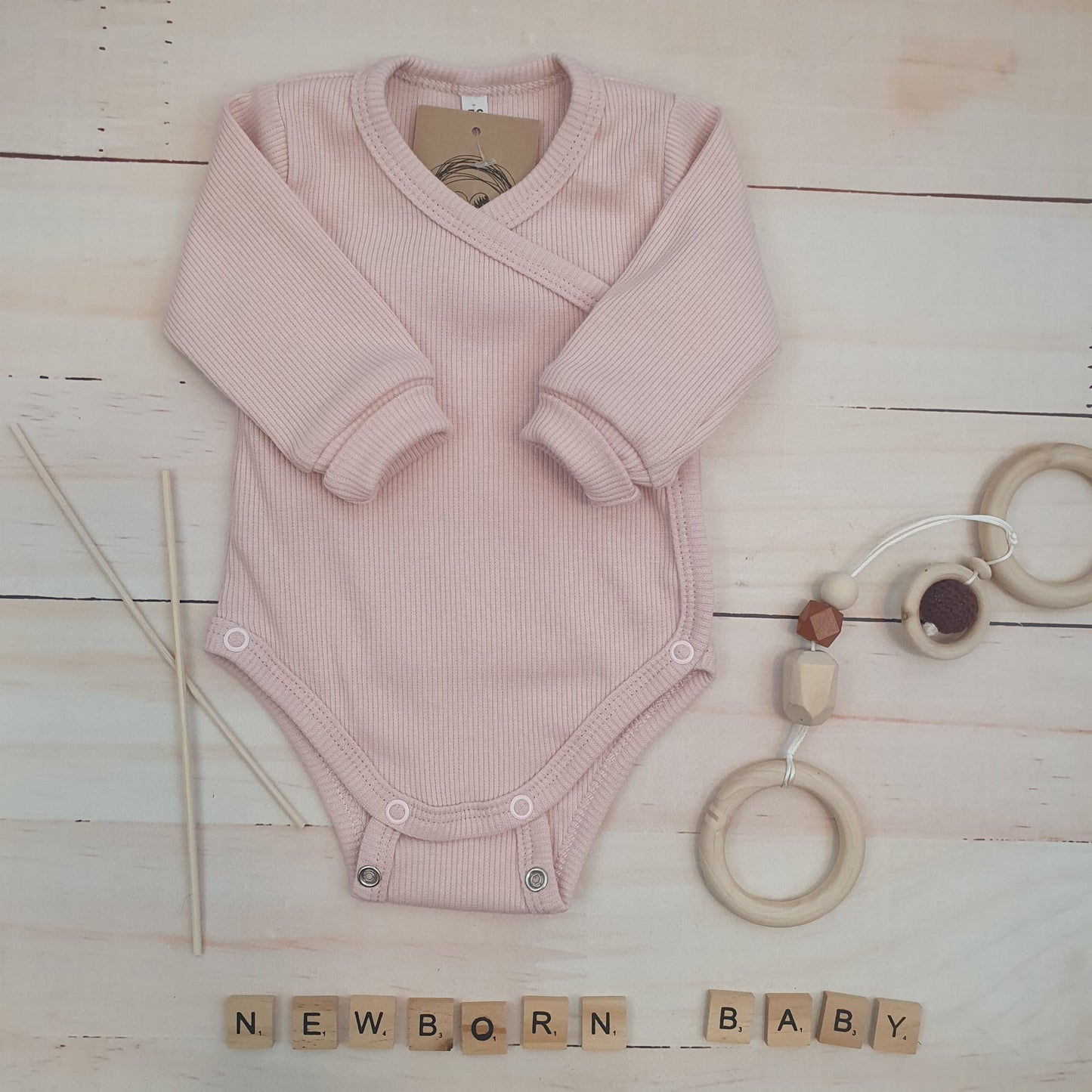 Bordázott, keresztpántos hosszú ujjú body állítható patenttal, rózsaszín