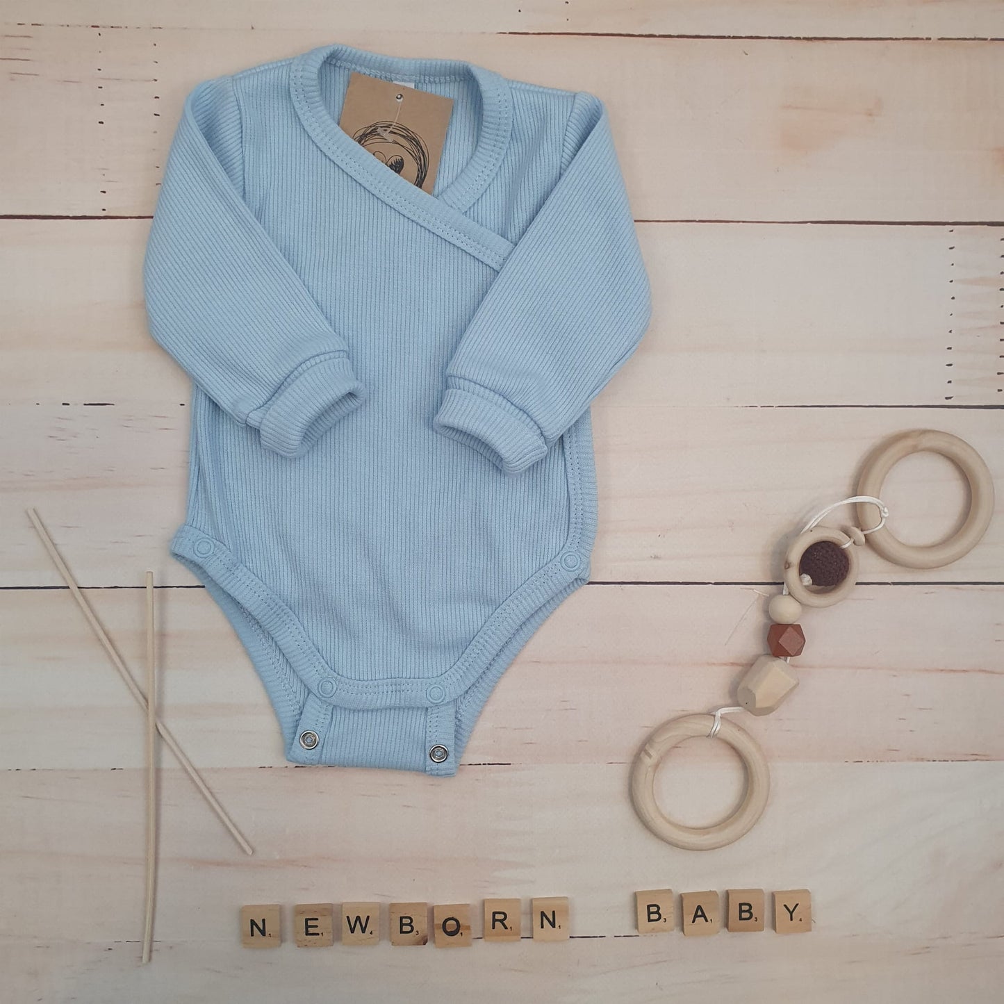 Bordázott, keresztpántos hosszú ujjú body állítható patenttal, rózsaszín