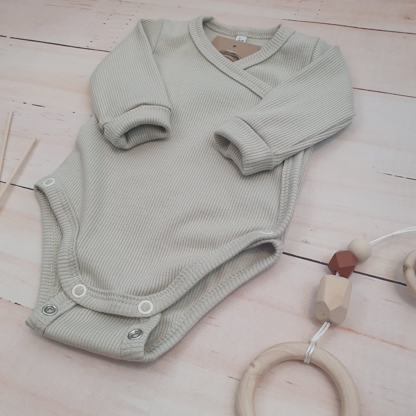 Bordázott, keresztpántos hosszú ujjú body állítható patenttal, rózsaszín